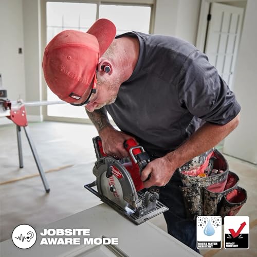 Man wearing red Milwaukee cap and earbud in ear while operating circular saw on jobsite.