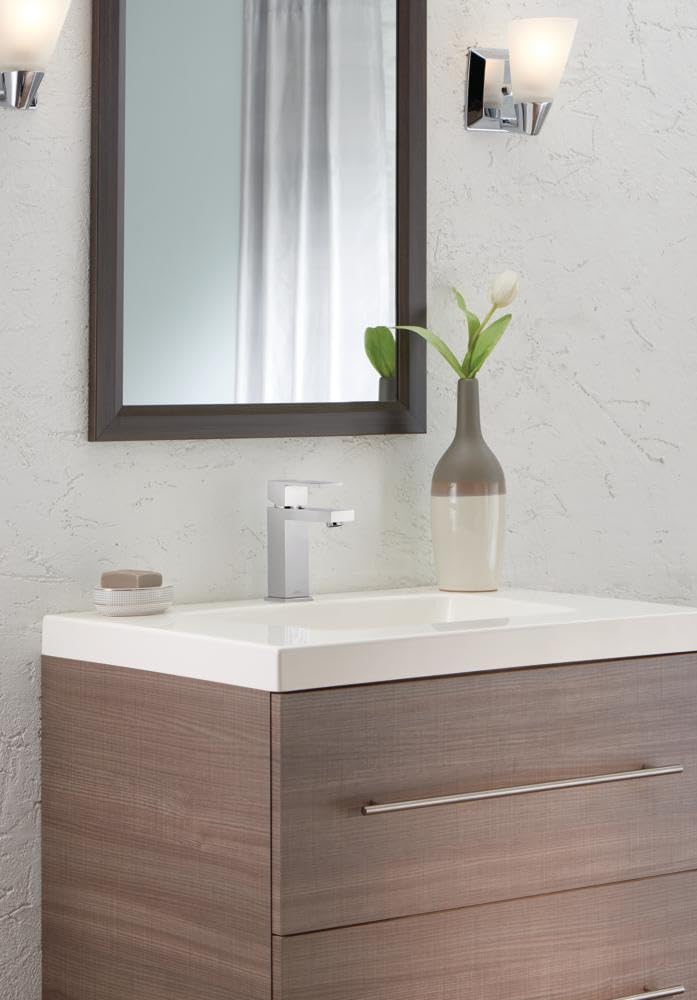 Chrome single-handle bathroom faucet with square spout installed on white sink vanity.