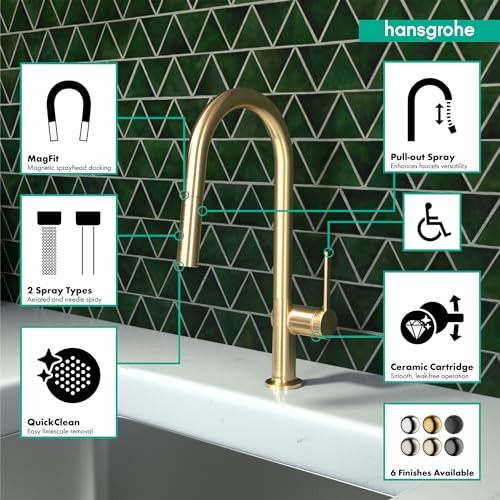 Brushed gold high-arc kitchen faucet with pull-down spray head mounted on white countertop against green patterned backsplash