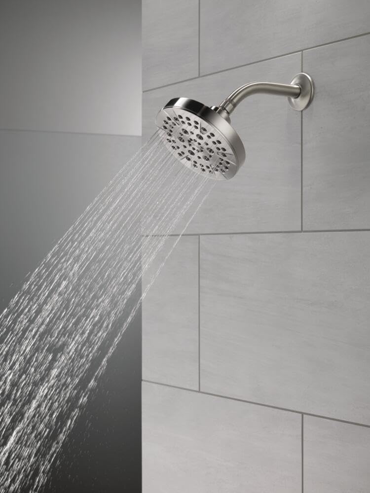 Chrome shower head with curved arm mounted on wall tile, water spraying downward in multiple streams.