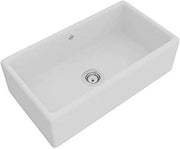 White fireclay apron front kitchen sink with single bowl and drain opening.