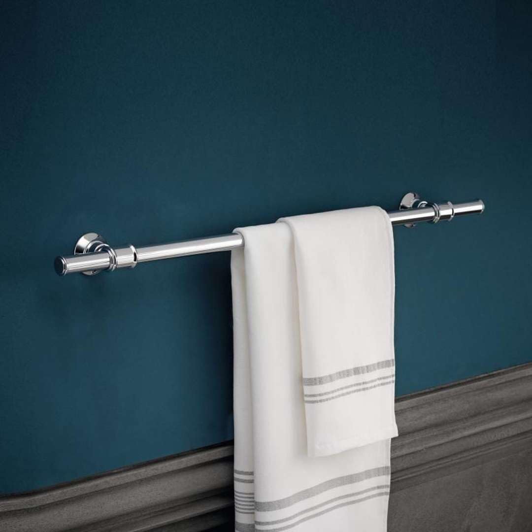 Chrome towel bar with cylindrical ends and decorative finials, displaying two folded white towels with gray stripes.