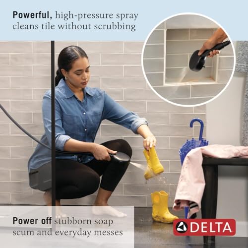 Matte black hand shower with hose spraying water on yellow cloth, demonstrating cleaning capability in bathroom setting.