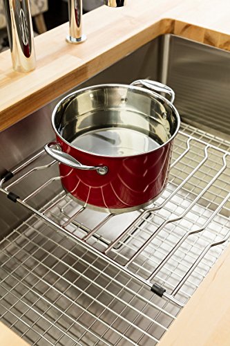 Stainless steel sink grid with rectangular openings supporting a red pot with lid inside bar sink.