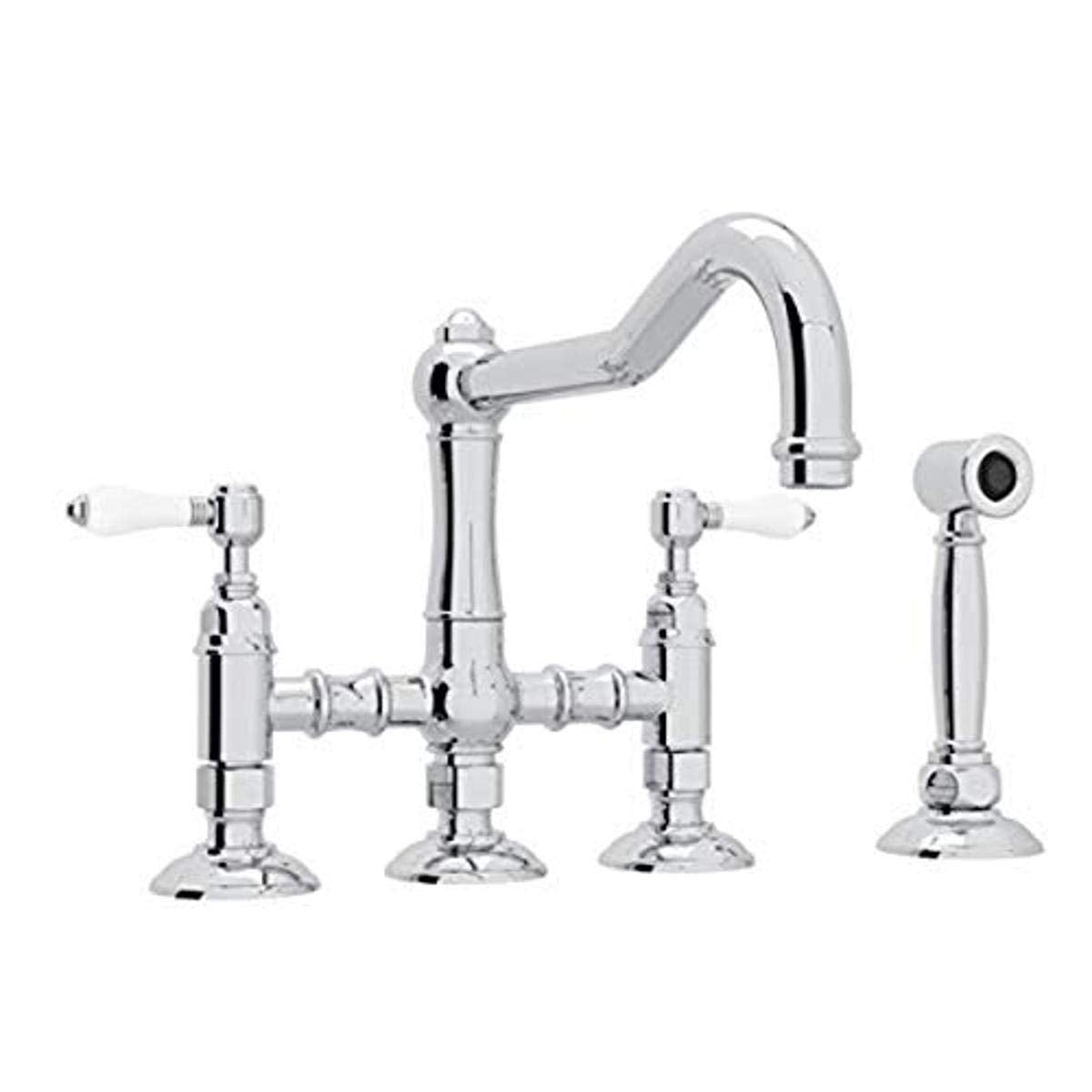 Polished chrome bridge kitchen faucet with curved spout, dual handles with white accents, and separate side spray attachment.