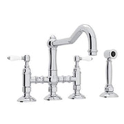 Polished chrome bridge kitchen faucet with curved spout, dual handles with white accents, and separate side spray attachment.