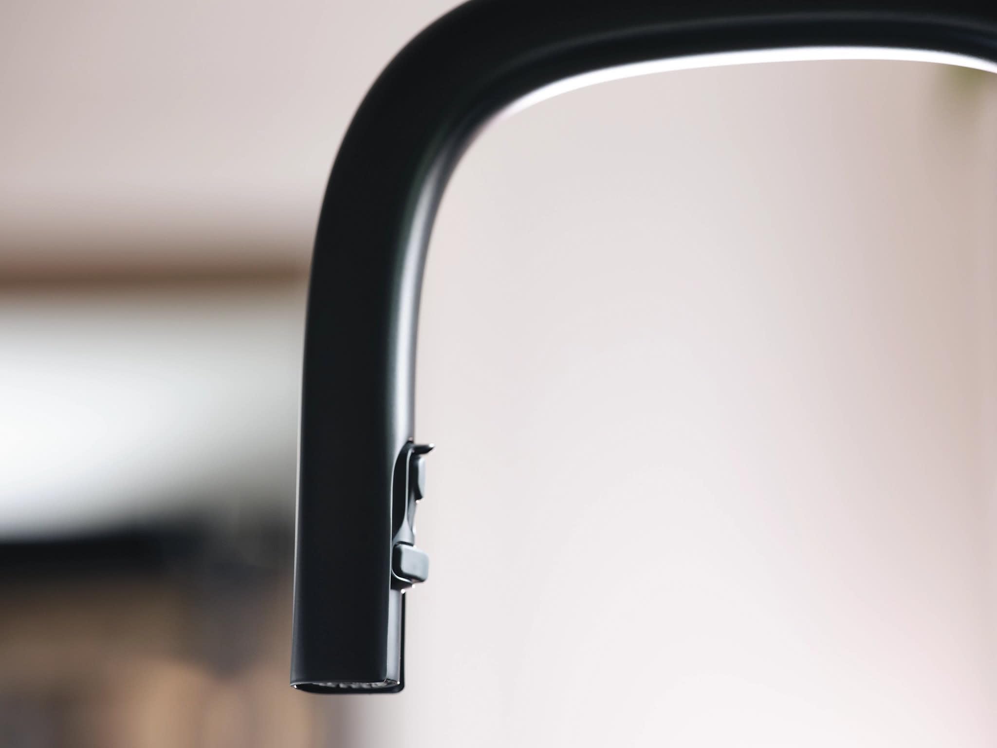 Matte black kitchen faucet with curved spout and pulldown spray head attachment.