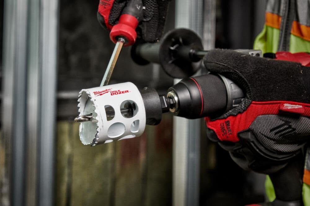 Milwaukee HOLE DOZER 3" bi-metal hole saw with pilot bit attached to drill chuck, white and black finish.