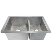 Brushed nickel double-bowl kitchen sink with hammered texture and drain holes visible.