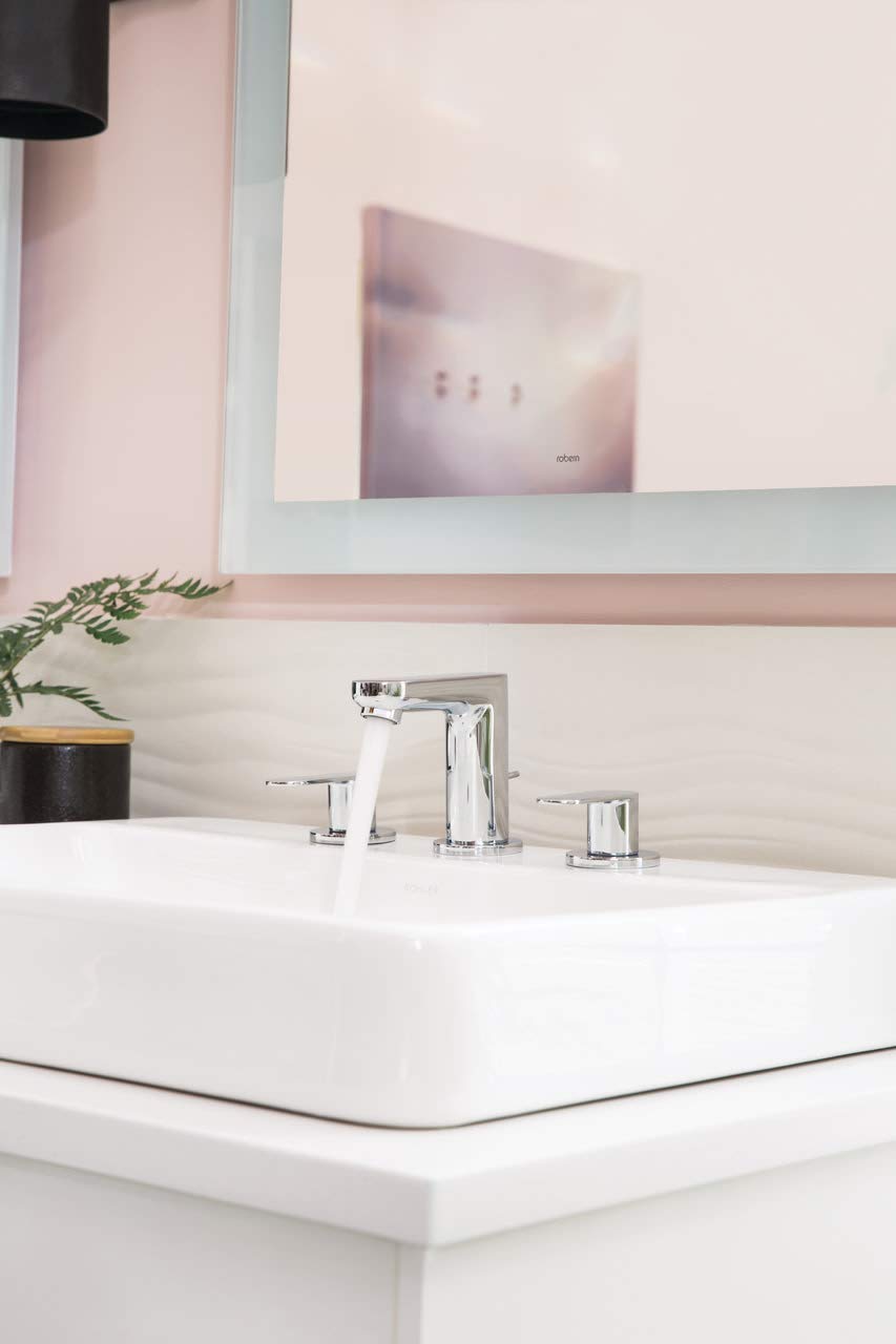 Chrome widespread bathroom faucet with center spout and two side handles mounted on white rectangular sink.