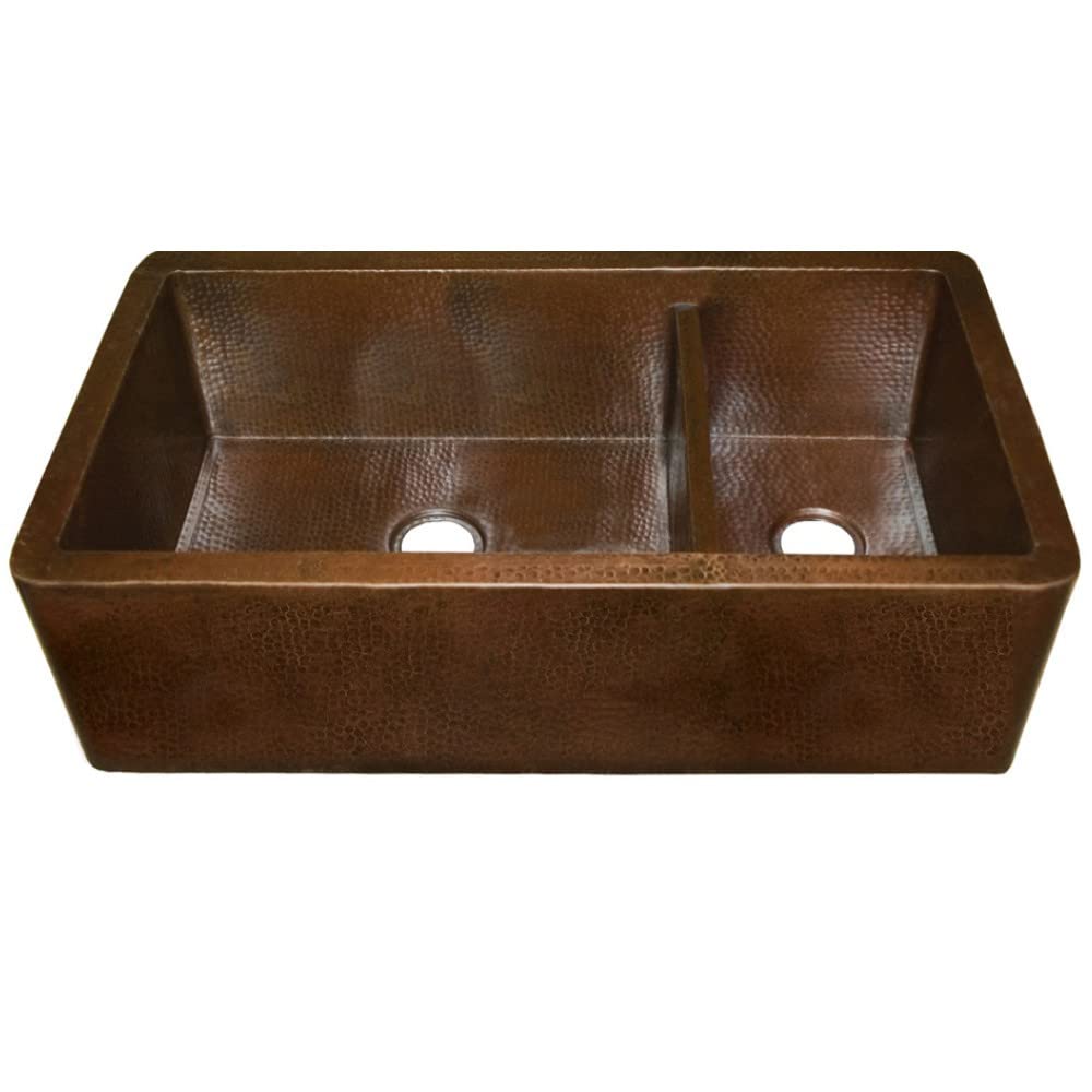 Antique copper farmhouse sink with two basins and hammered interior finish.