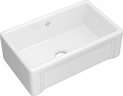 White fireclay farmhouse apron front kitchen sink with single bowl and drain opening.