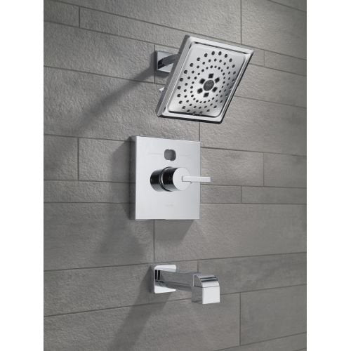 Oil-rubbed bronze shower arm mounted to tile wall with square showerhead and control valve.