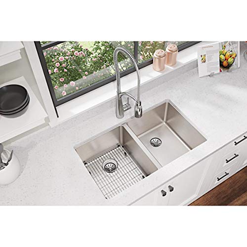 Stainless steel sink grid with crosshatch pattern, positioned in left compartment of double basin sink.