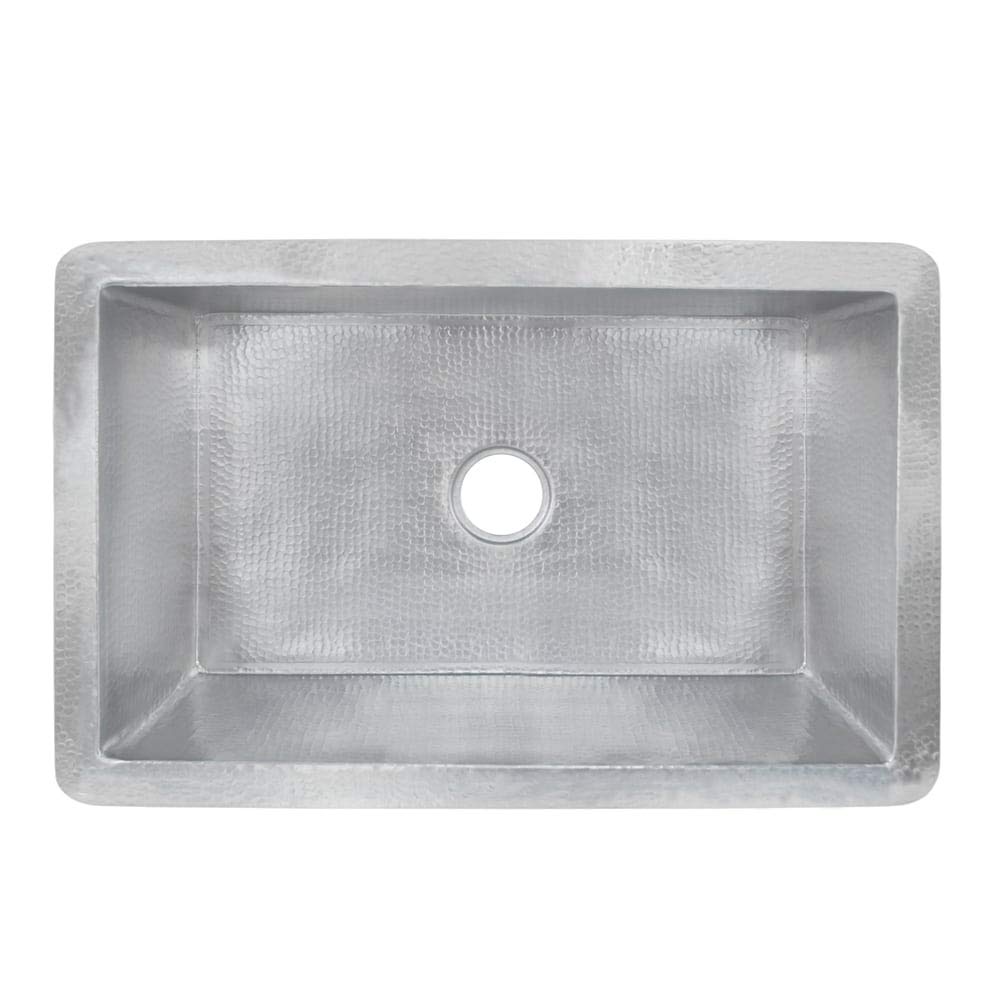 Brushed nickel single-basin kitchen sink with hammered interior and rounded front apron, drain opening centered.