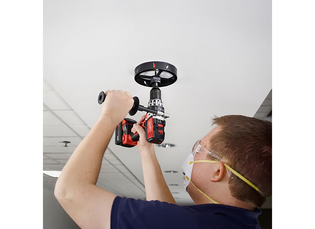 Milwaukee recessed light hole saw with black wheel handle and red drill attachment being used to cut ceiling opening.