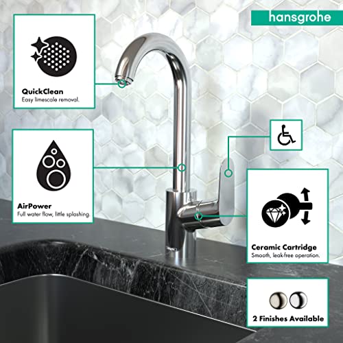 Chrome bar faucet with curved spout and single handle over black sink countertop.