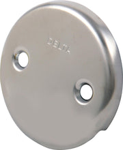 Stainless steel overflow plate with Delta branding and two mounting holes.