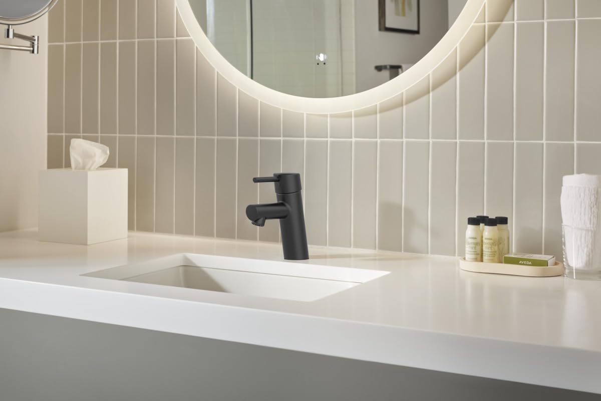 Matte black single-handle bathroom faucet with curved spout installed on white sink counter.
