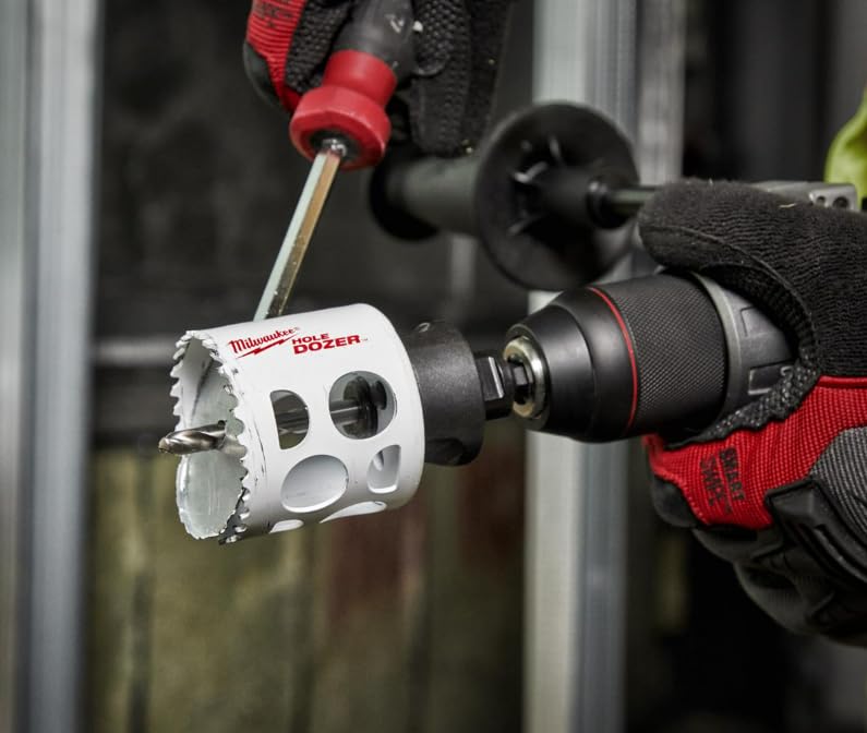 Milwaukee HOLE DOZER bi-metal hole saw with white and black body attached to drill chuck, held by gloved hand.