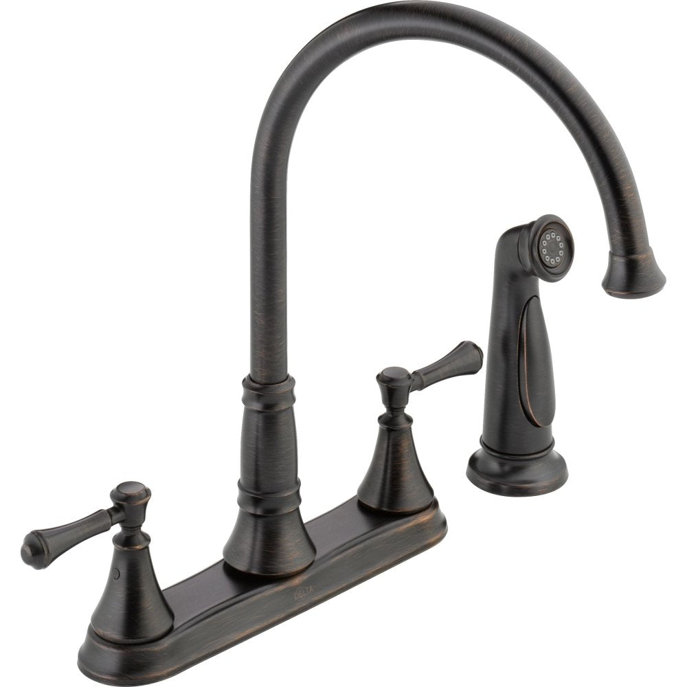 Two-handle kitchen faucet with curved spout, spray head, and lever handles in oil-rubbed bronze finish.
