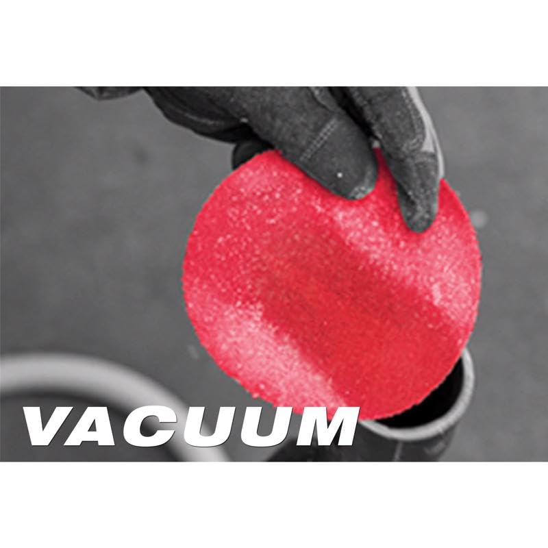 Red circular sanding sheet with perforated surface held in gloved hand.