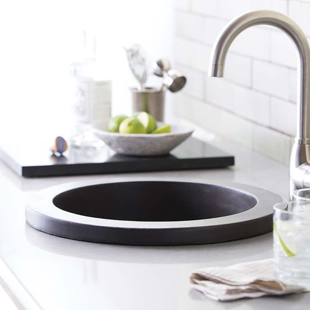 Slate-colored round bar sink with metal rim and brushed nickel faucet on white countertop.