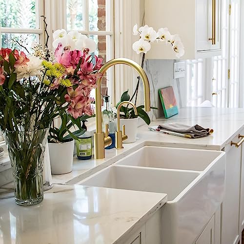 Stainless steel pull-down kitchen faucet with arched spout installed above a double basin sink.