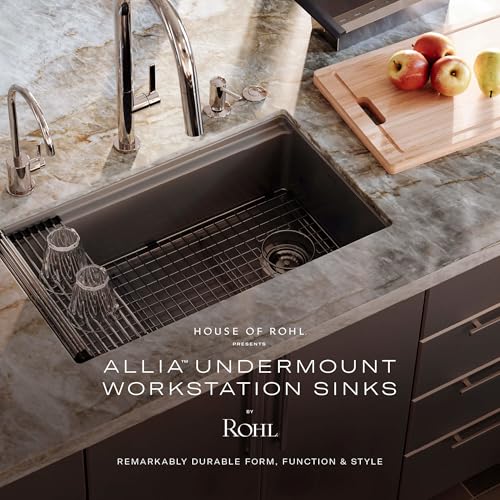 White fireclay undermount sink with dark interior basin, metal grid insert, and chrome faucet installed in marble countertop.