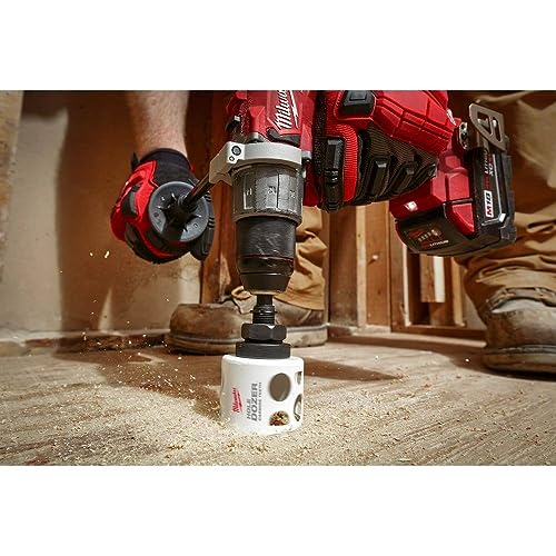 Milwaukee 11/16" carbide-toothed hole saw attached to red drill press drilling into wood.