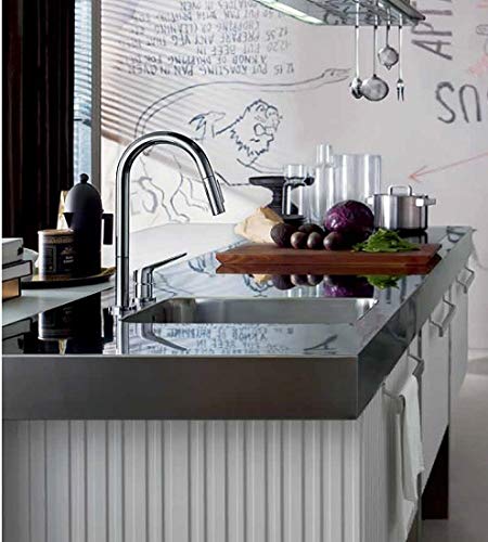 Chrome pull-down kitchen faucet with curved spout mounted on dark sink basin with vegetables and kitchenware.