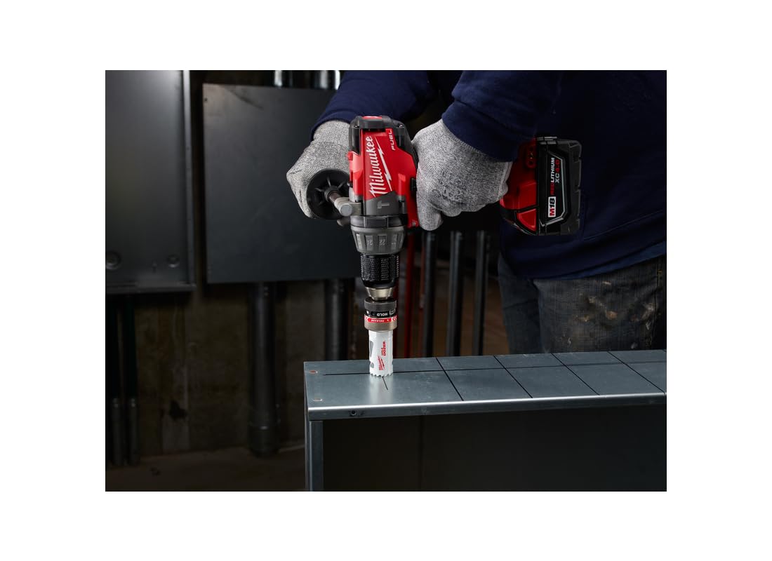 Milwaukee cordless drill with hole saw bit attached, held by gloved hands above metal surface.