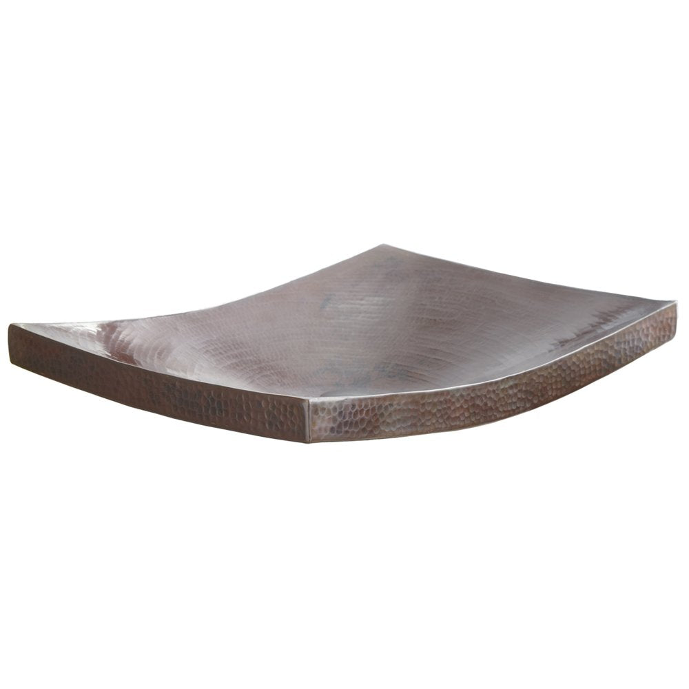 Antique copper vessel sink with curved sides and hammered surface texture.
