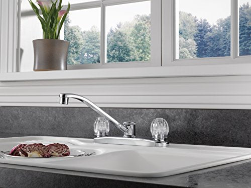 Chrome two-handle kitchen faucet with curved spout installed on countertop sink.