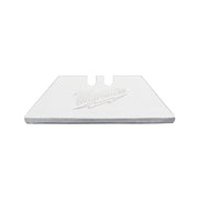 Silver Milwaukee utility knife blade with trapezoid shape and center slot for blade holder attachment.