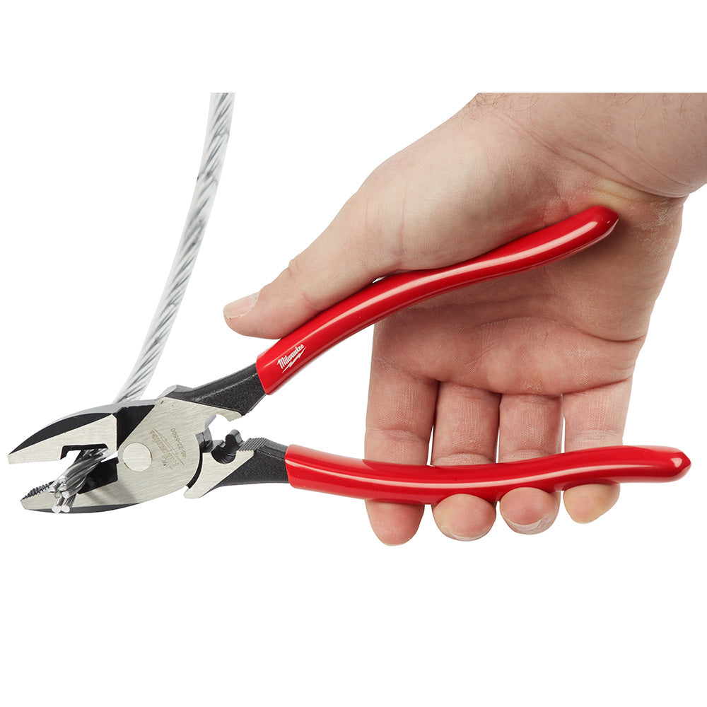 Red-handled linesman's pliers with black jaw and dipped grip, held in hand next to coiled wire.