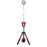 Tall tower light with hexagonal LED head on telescoping pole, red body with black tripod base and hanging work light.