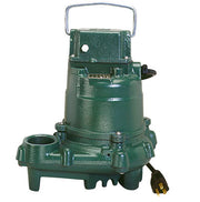 Green cast-iron effluent pump with handle, outlet ports, and yellow power cord visible.