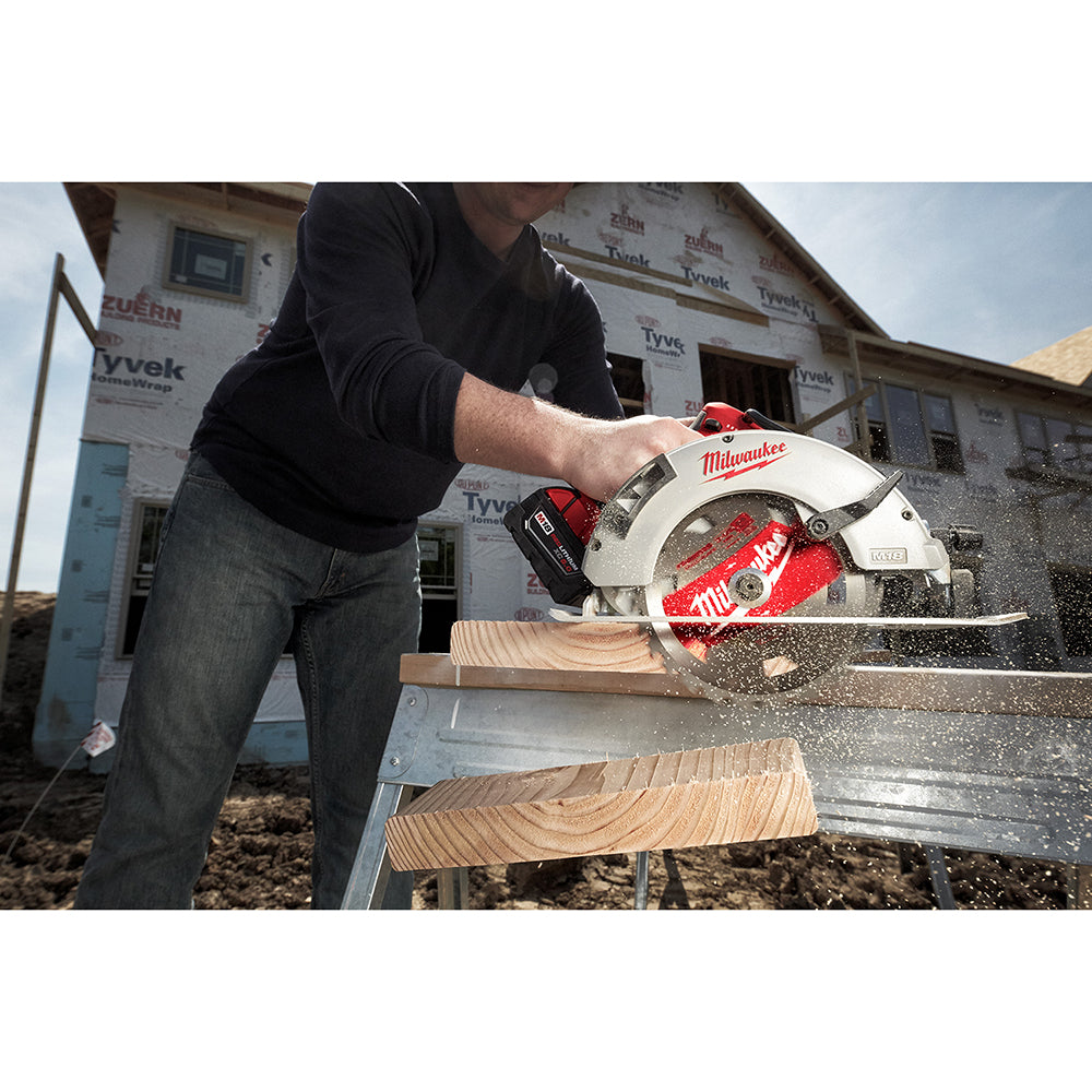 Milwaukee circular saw with red blade cutting through wooden lumber on a job site.