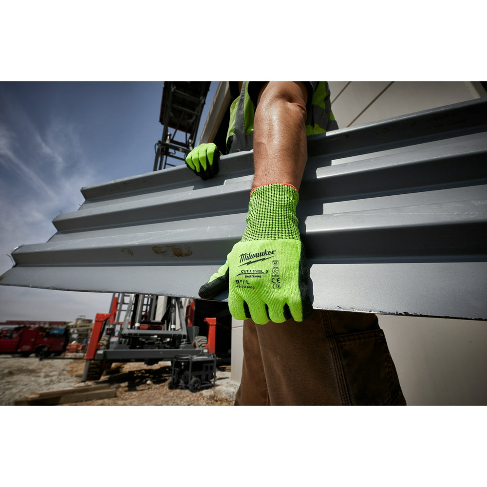 Bright yellow-green work gloves with polyurethane coating worn while gripping metal beams on a construction site.