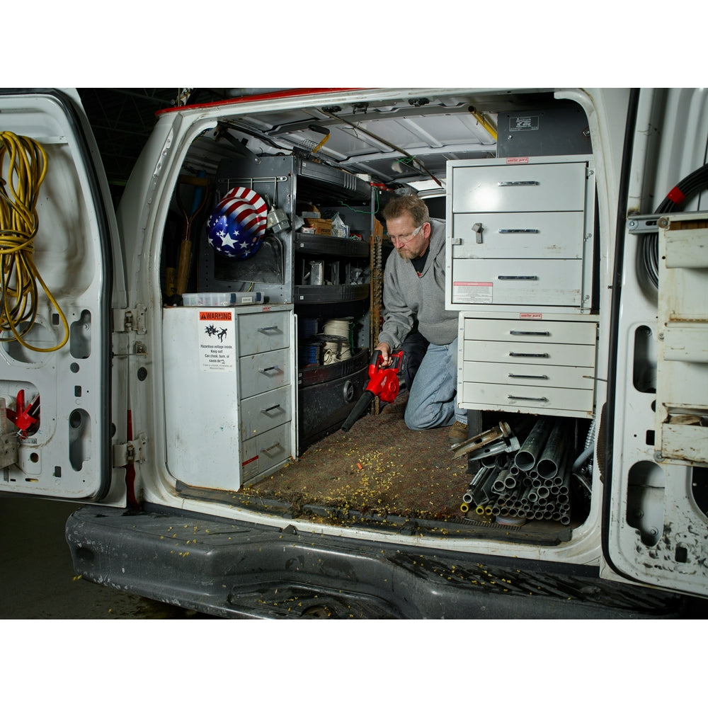 White Milwaukee M18 compact blower with black motor housing displayed in work van with tools and equipment.