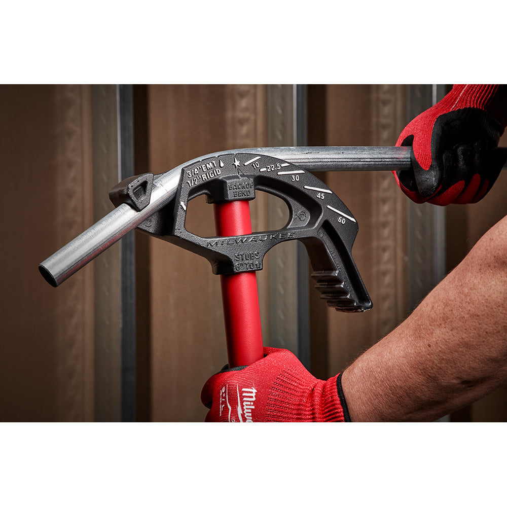 Milwaukee 3/4 in. iron conduit bender with red handle and degree markings, held in gloved hands.