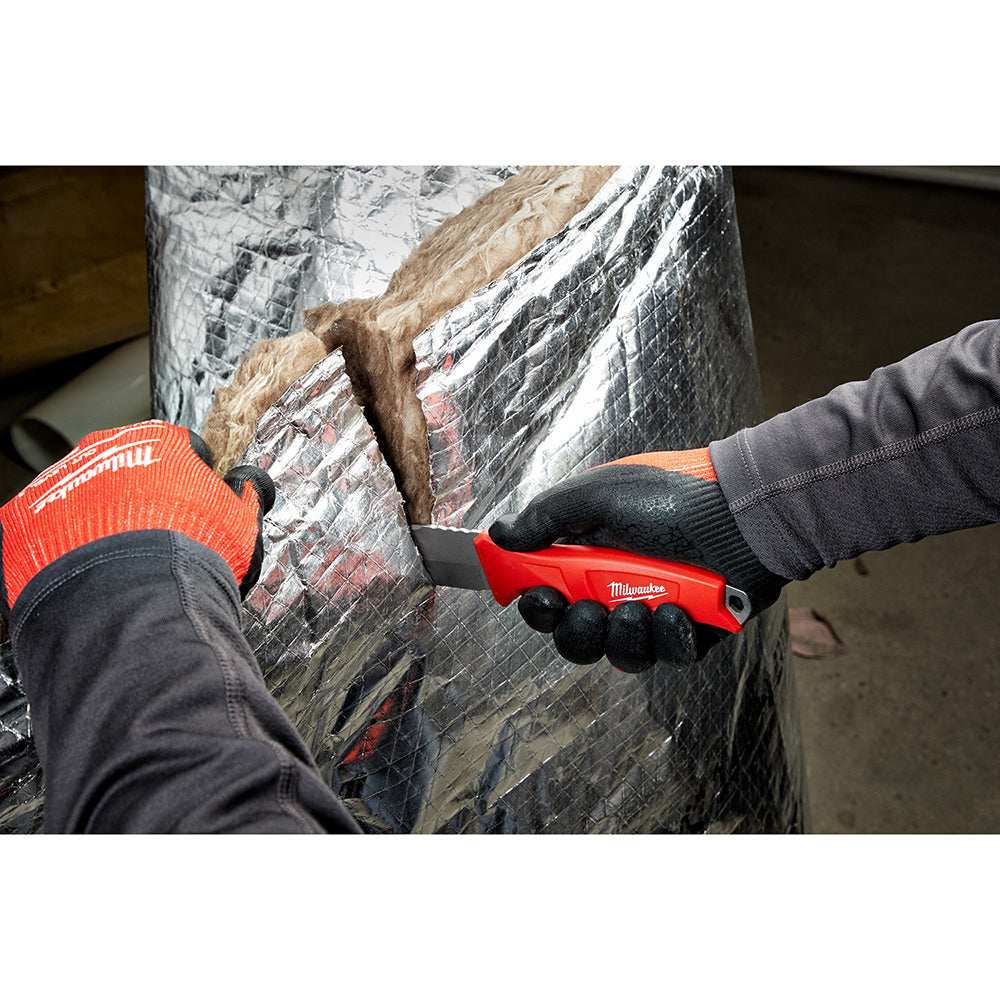 Milwaukee fixed blade knife with red and black handle being used to cut insulation material.