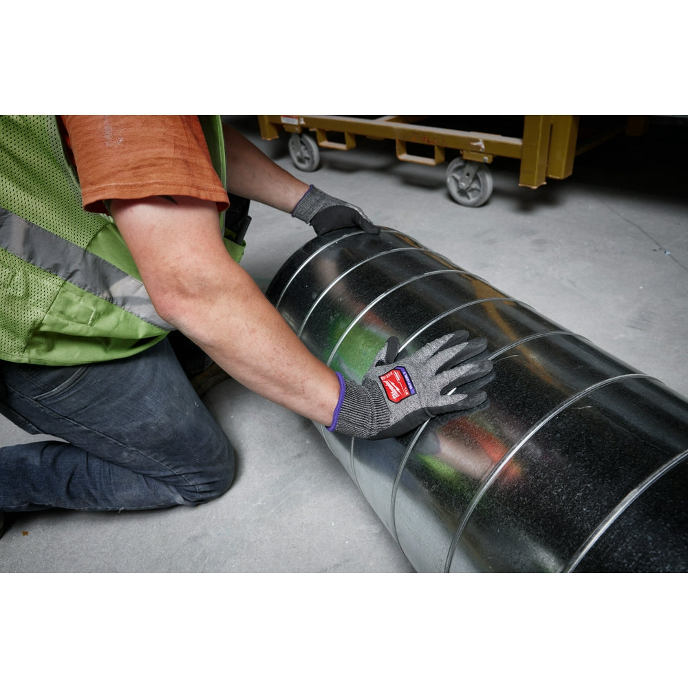 Black nitrile-dipped work glove with gray knit upper and purple stripe being worn while handling a metal barrel.