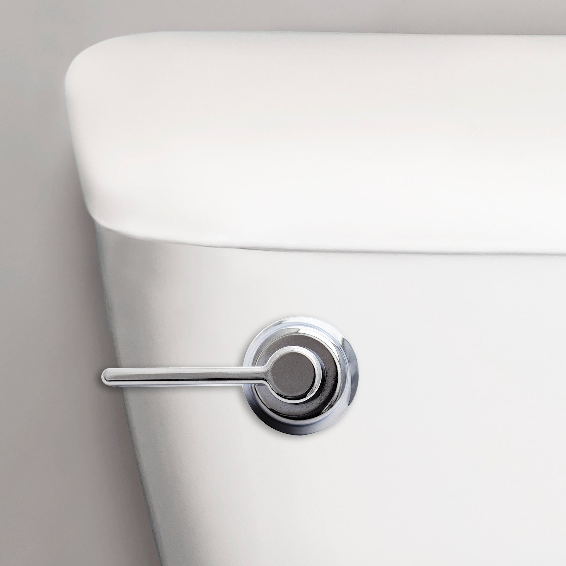 Chrome toilet handle with lever-style arm mounted on white porcelain tank.