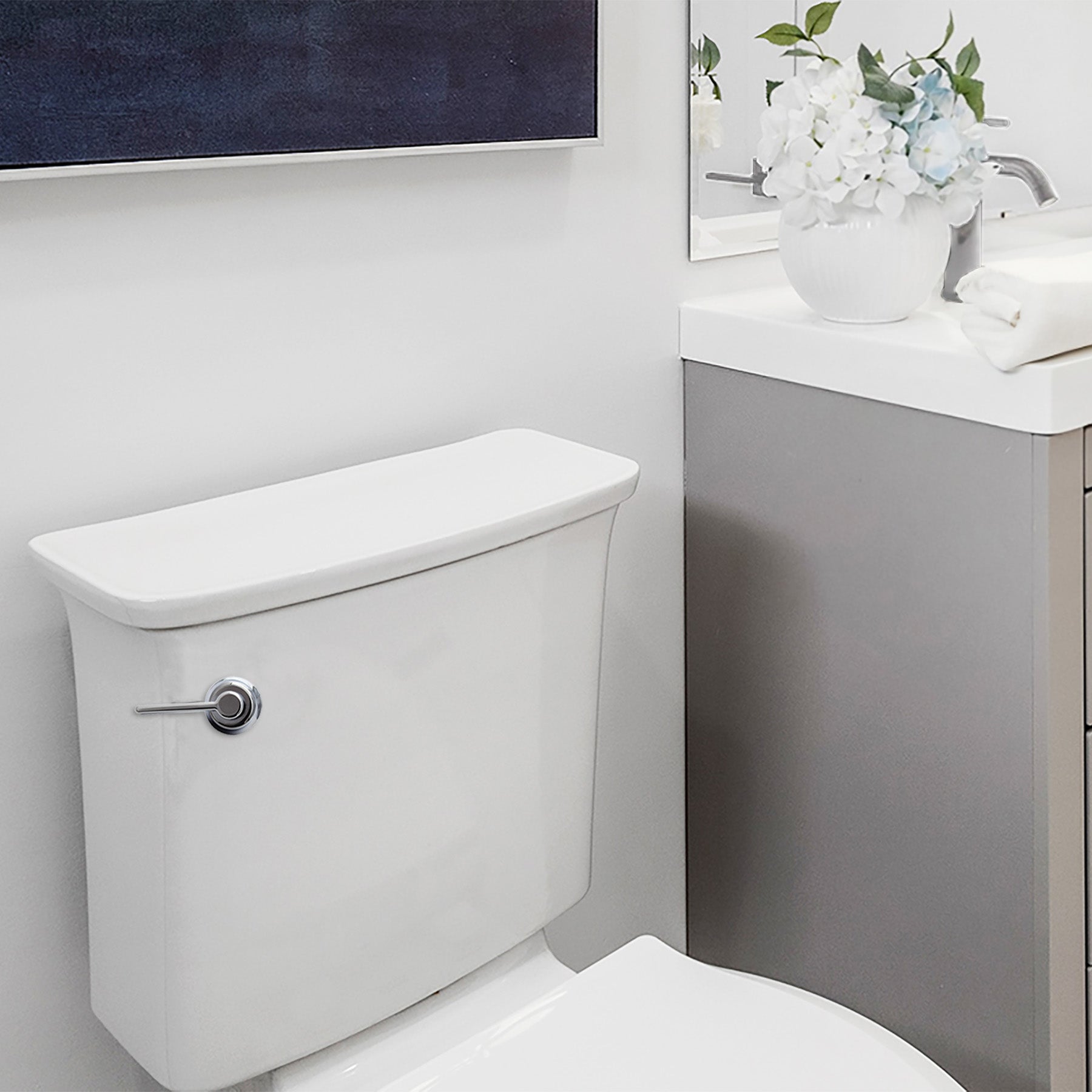 Chrome toilet handle lever mounted on white porcelain tank in bathroom setting.