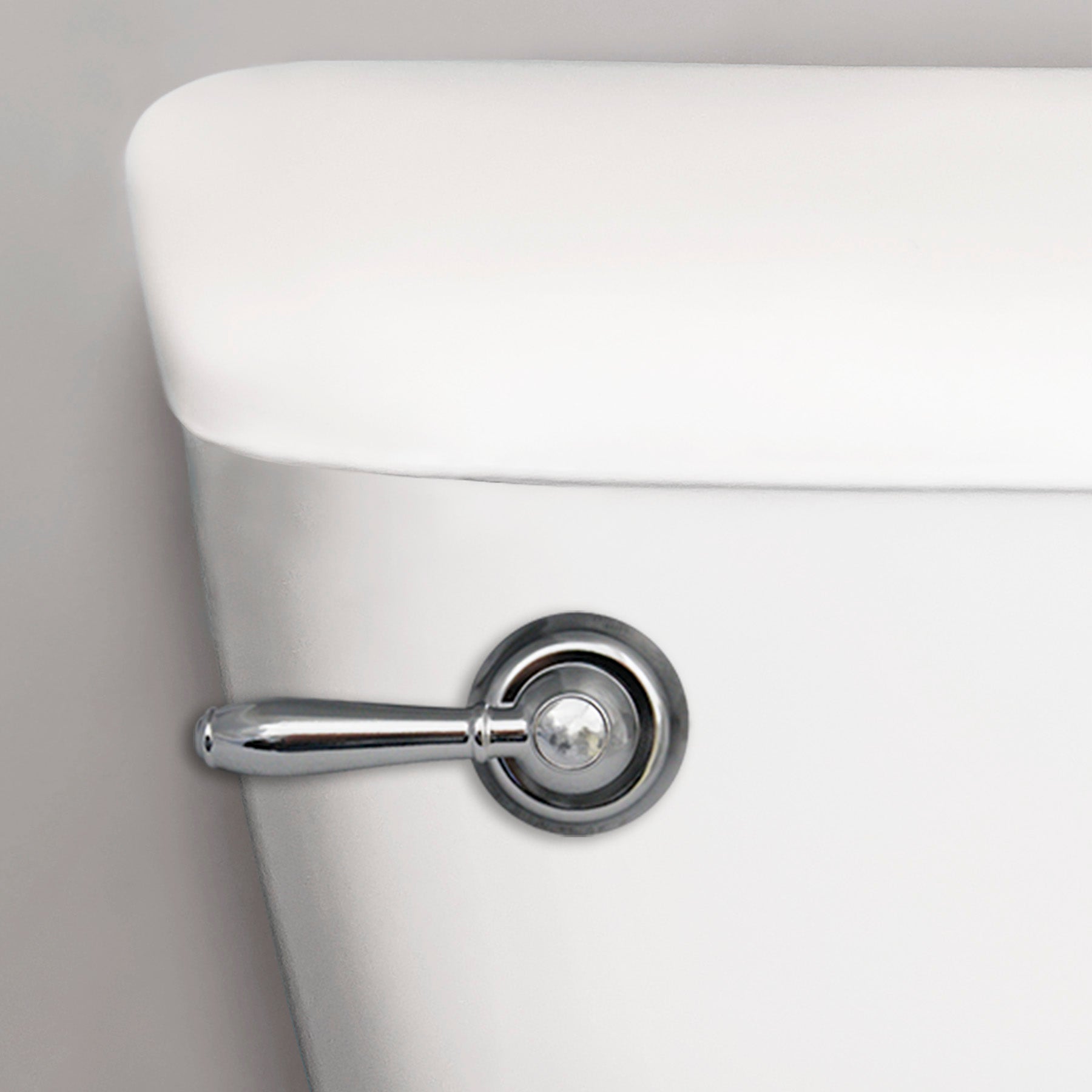 Chrome lever-style toilet handle mounted on white porcelain tank with circular backing plate.
