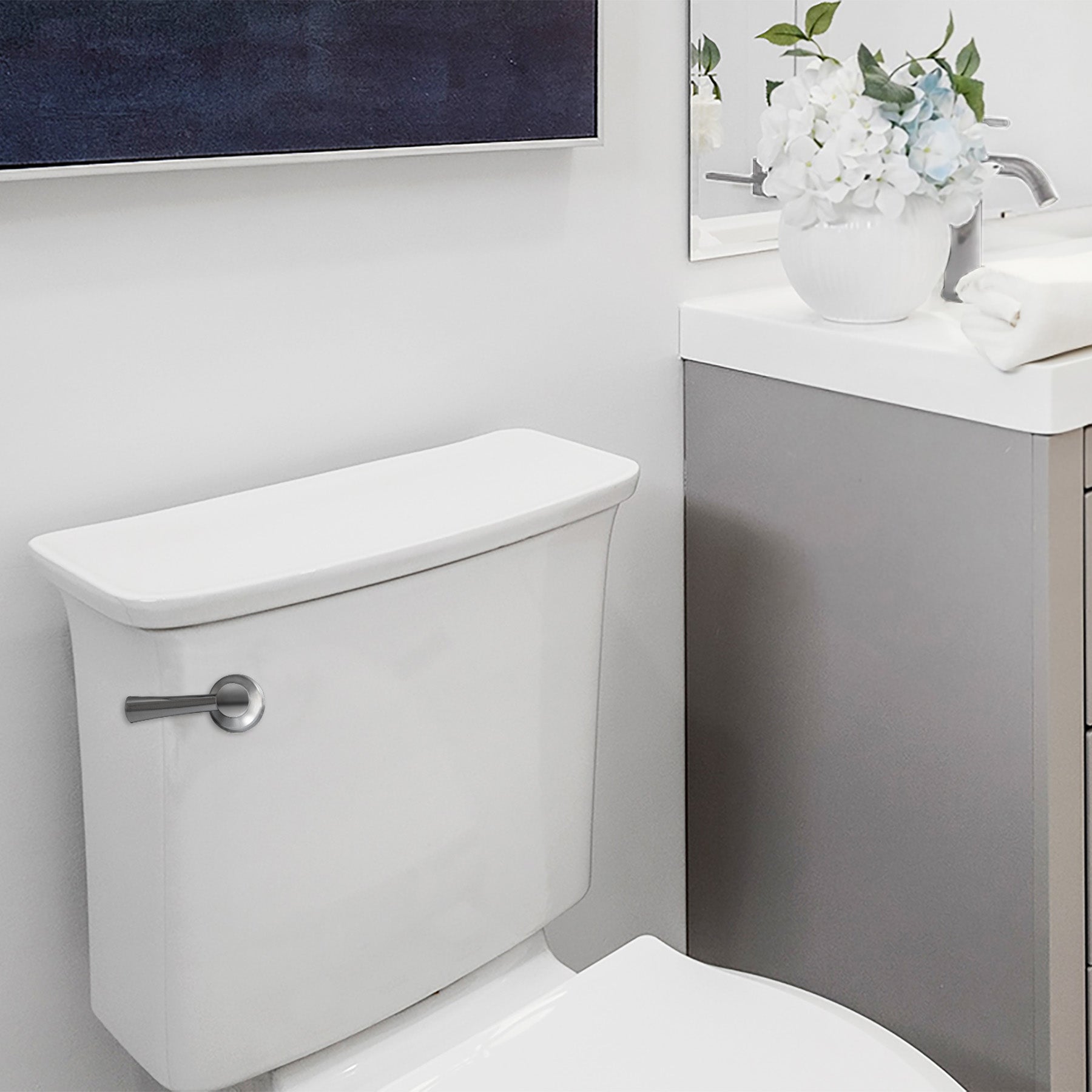 Chrome lever toilet handle mounted on white porcelain tank in bathroom setting.