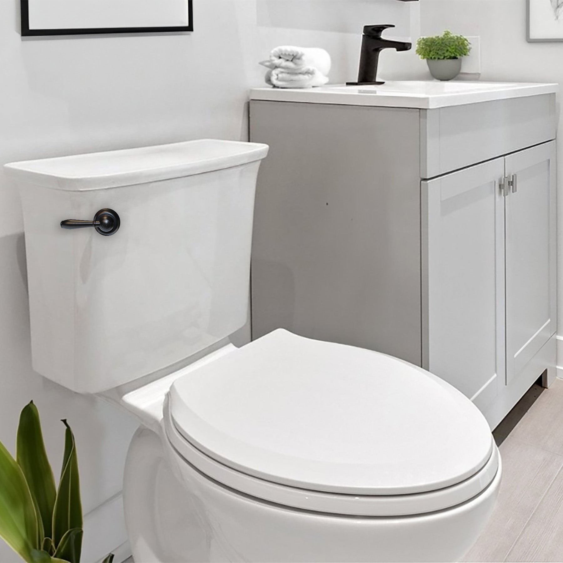 Oil rubbed bronze toilet handle lever mounted on white porcelain tank in bathroom setting.
