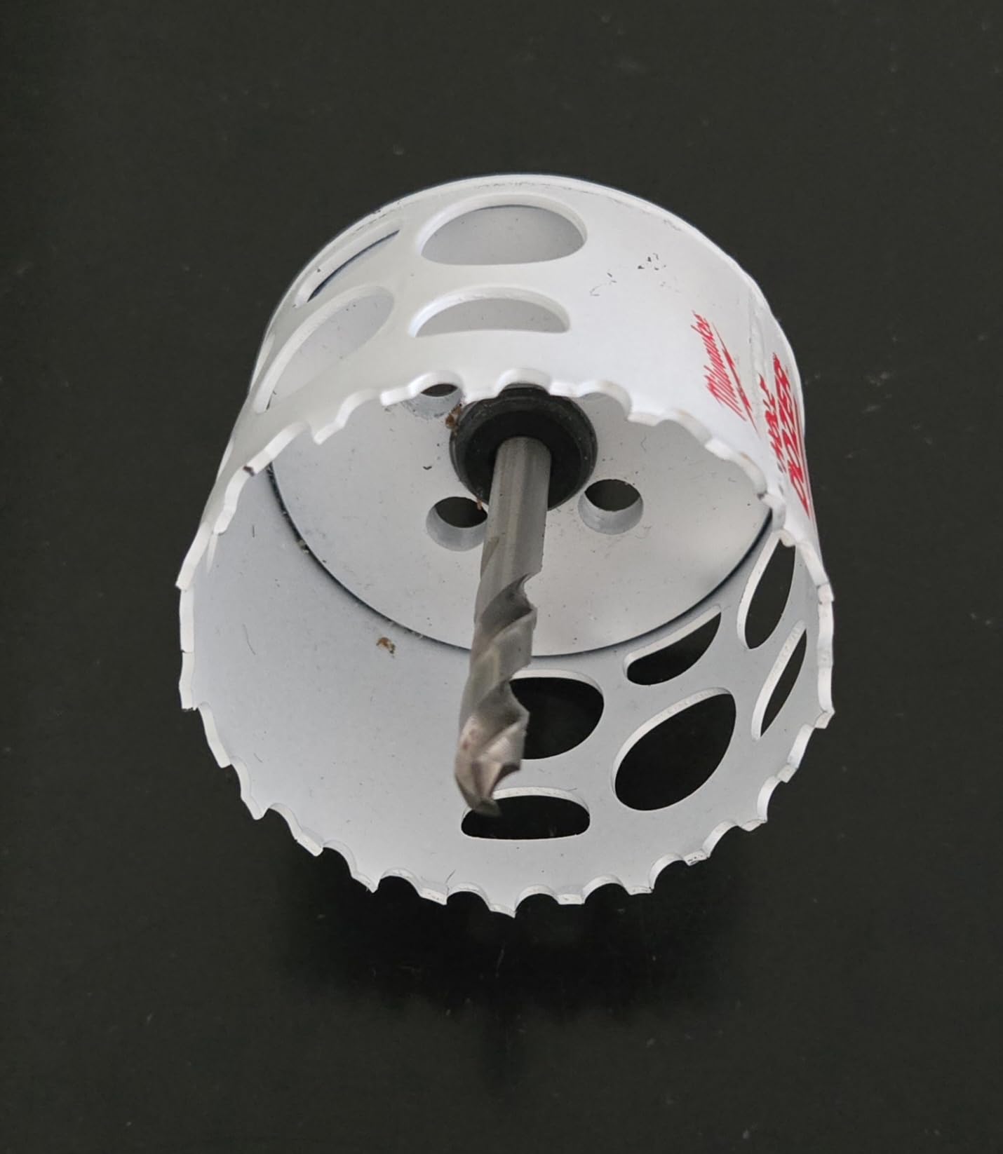 White bi-metal hole saw with central arbor shaft and ventilation slots around the cylindrical body.